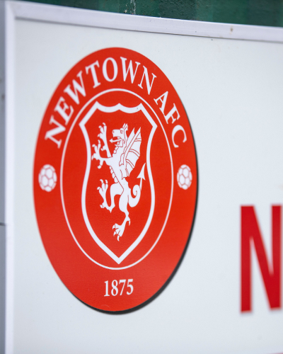 Newtown have confirmed the signing of defender Theo Ezea